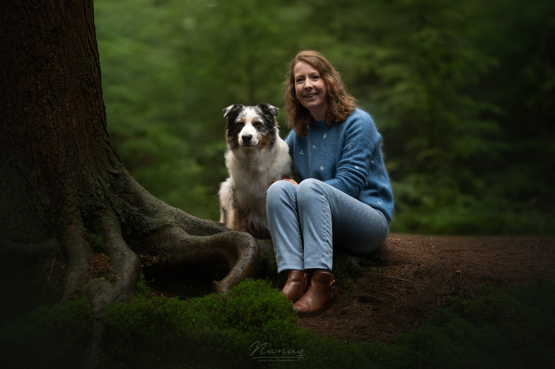 Charlotte Olsthoorn, eigenaresse van holistische praktijk voor dieren, met haar Australian Shepherd Liv springend in het bos